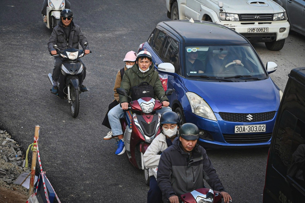 Người đi xe máy lỉnh kỉnh đồ đạc về quê trong kỳ nghỉ Tết kéo dài 9 ngày.