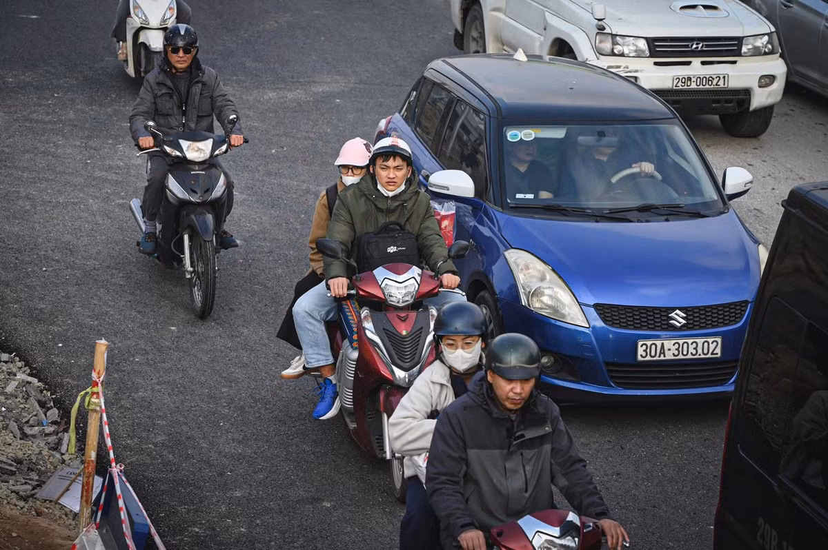 Người đi xe máy lỉnh kỉnh đồ đạc về quê trong kỳ nghỉ Tết kéo dài 9 ngày.