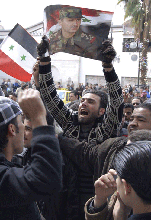 Ngày 25/3/2011- Một người ủng hộ Tổng thống Bashar Assad giơ cao ảnh chân dung ông trong một cuộc biểu tình bên ngoài Thánh đường Hồi giáo Omayyad tại Damascus.