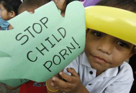 Một em bé giơ cao khẩu hiệu "Ngăn chặn nạn khiêu dâm trẻ em" trong một cuộc mít tinh chống khiêu dâm trẻ em.