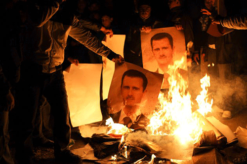Ngày 9/4/2012 – Người biểu tình đốt ảnh Tổng thống Assad tại Binnish, Syria.