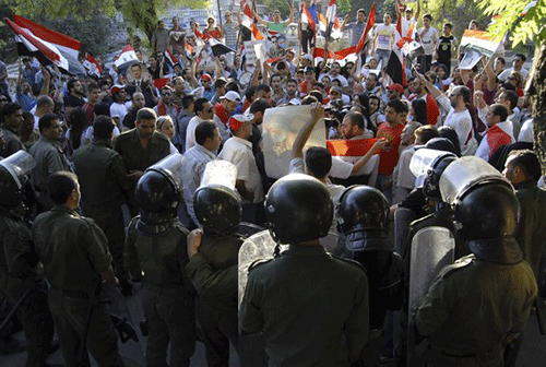 Ngày 9/6/2011 - Cảnh sát chống bạo loạn Syria đứng bảo vệ người biểu tình ủng hộ Tổng thống Syria Bashar Assad trong một cuộc biểu tình gần trụ sở Liên minh châu Âu tại Damascus.