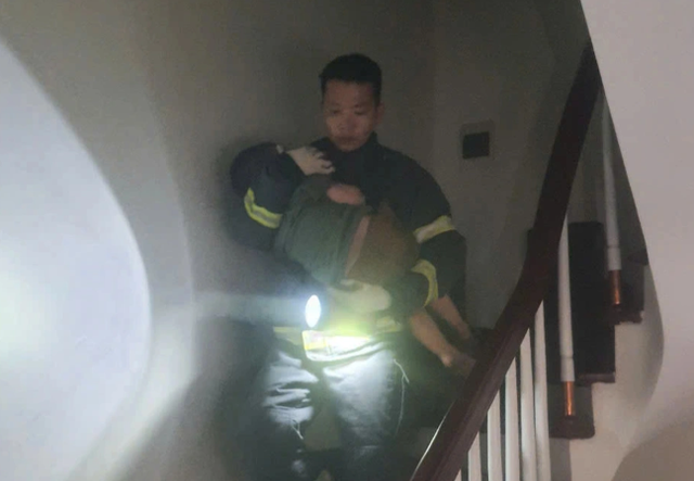 Lực lượng chức năng đưa các em nhỏ thoát khỏi vụ cháy. capture.png