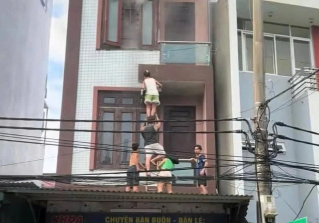 Người dân dùng thang, đưa các nạn nhân trong ngôi nhà cháy thoát nạn xuống dưới an toàn. capture-5402.png