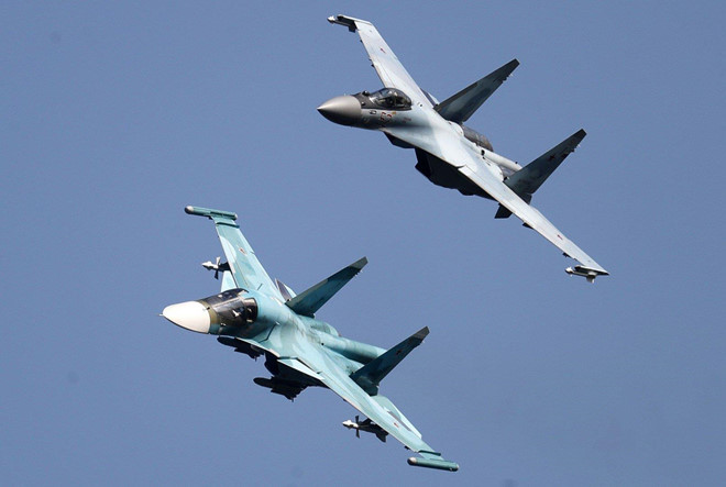 Tiêm kích Su-35 (trên) và Su-34 (dưới) bay biểu diễn tại triển lãm. Đây là 2 chiến đấu cơ thế hệ 4++ hiện đại nhất của Nga. Su-35 sẽ kế thừa vai trò của Su-27, trong khi Su-34 sẽ đảm nhận nhiệm vụ cường kích thay thế cho Su-24. Ảnh: EFE.