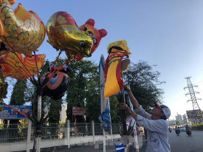 Người bán hàng treo đầu lân, mong mua may bán đắt trong năm mới.