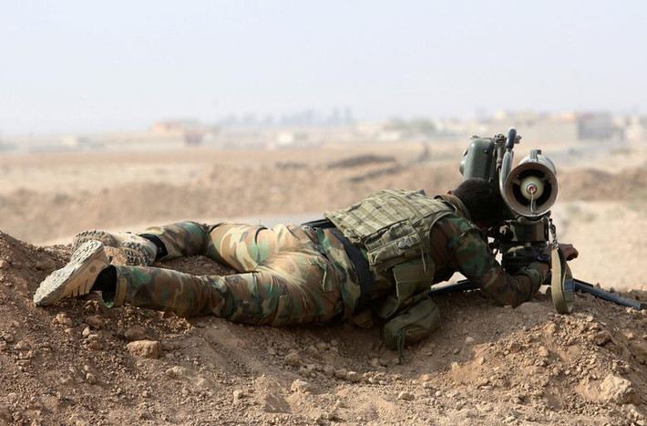Một chiến sĩ người Kurd đang nhắm bắntrước cuộc tấn công nhằm vào ngôi làng Fadiliya do Nhà nước Hồi giáo nắm giữ, phía BắcMosul, Iraq, tháng 10/2016.