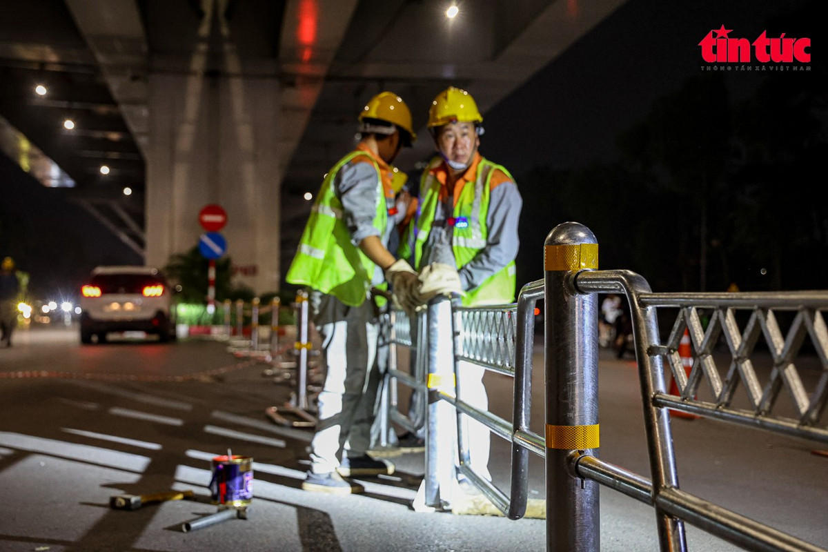 Công nhân kiểm tra mối hàn tại các khớp nối của hàng rào phân làn.