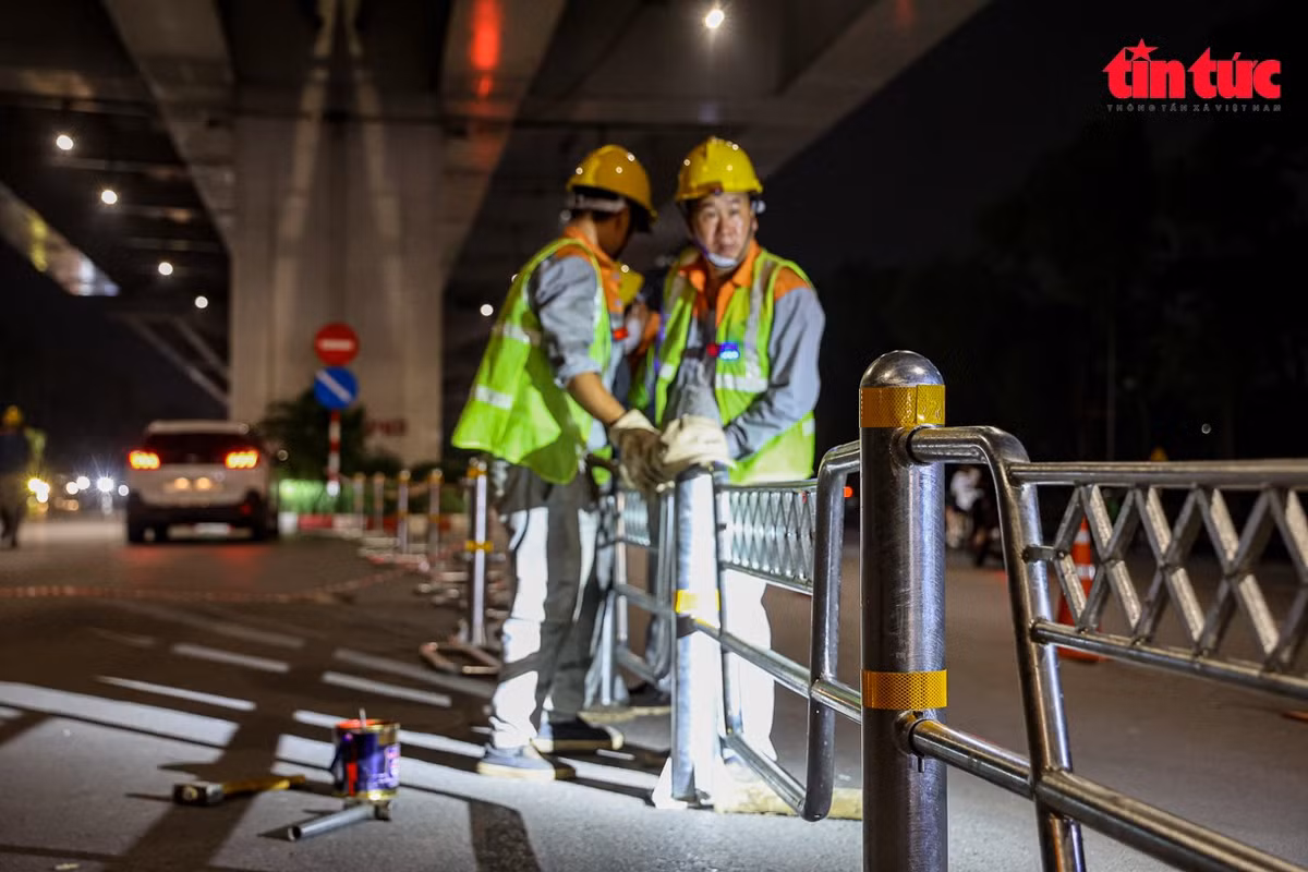 Công nhân kiểm tra mối hàn tại các khớp nối của hàng rào phân làn.