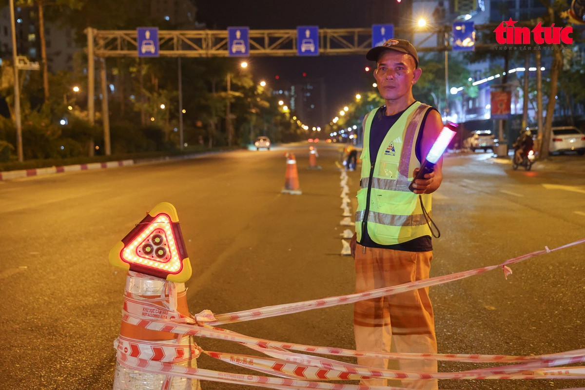 Công nhân căng dây phân luồng tạm thời, bảo đảm an toàn khu vực thi công.