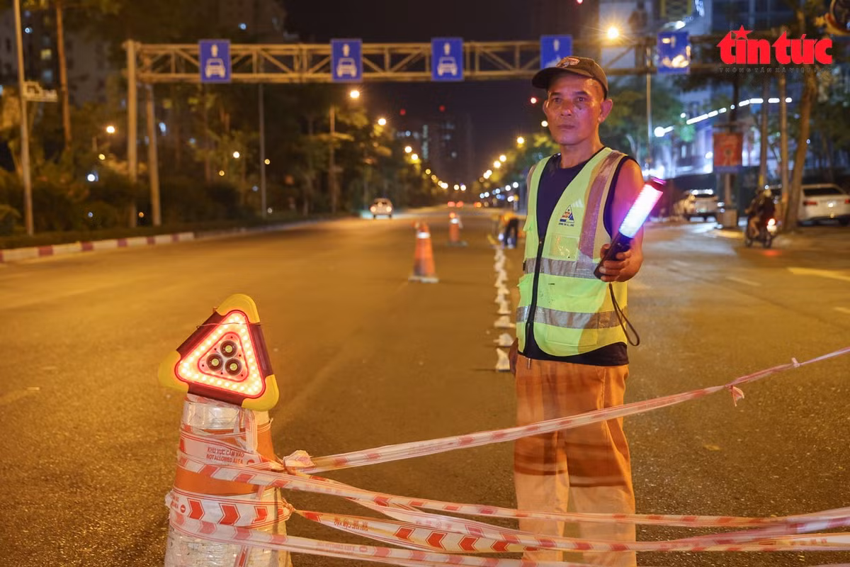 Công nhân căng dây phân luồng tạm thời, bảo đảm an toàn khu vực thi công.