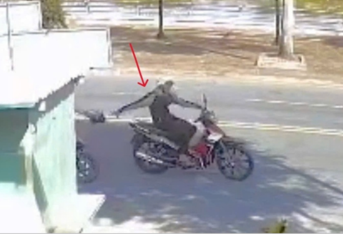 Đối tượng trùm áo khoác màu đen đang thực hiện hành vi cướp giật tài sản. Ảnh chụp từ camera an ninh