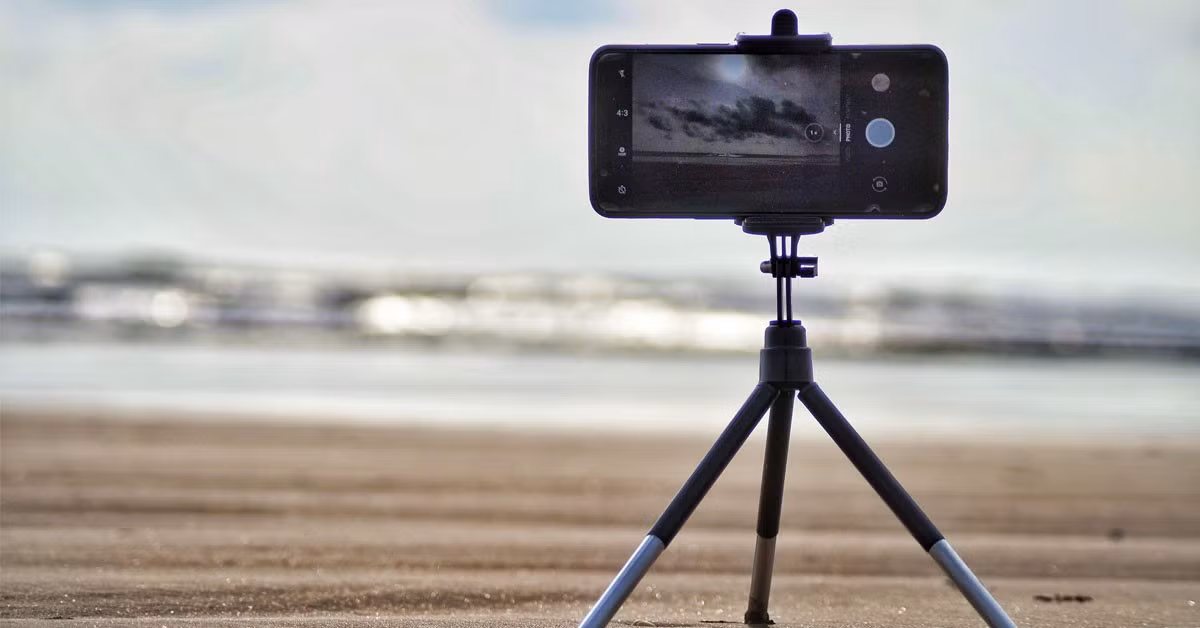 Chân máy (tripod) là công cụ rất cần thiết khi chụp ảnh siêu trăng bằng điện thoại vì nó giúp giữ máy cố định, hạn chế rung tay làm ảnh bị nhòe. Đặc biệt, khi phải phơi sáng lâu hoặc zoom gần, chân máy giúp ảnh sắc nét rõ rệt hơn. Nếu không có tripod, bạn có thể tận dụng những chỗ cố định như mỏm đá, lan can hay cửa sổ để đặt điện thoại cho ổn định.