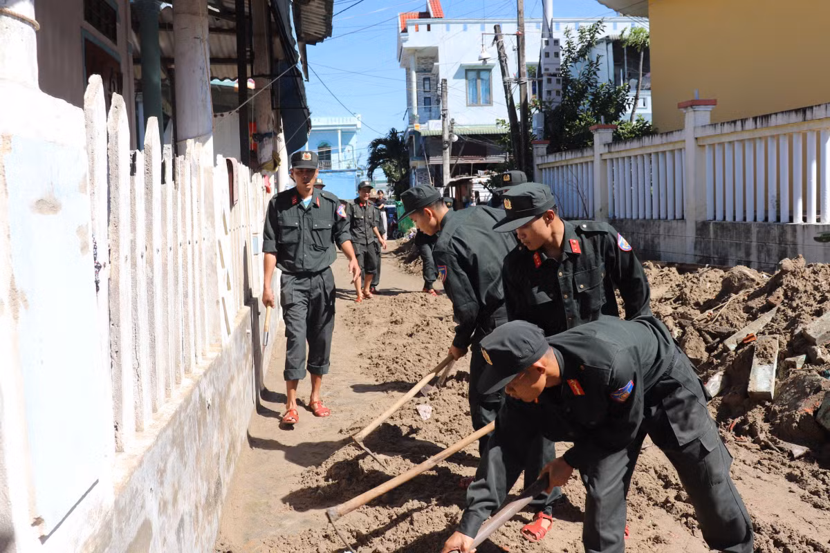 Lực lượng cảnh sát cơ động trong sáng ngày 7/11 được huy động thu gom, san gạt đất cát tạm thời khôi phục giao thông.