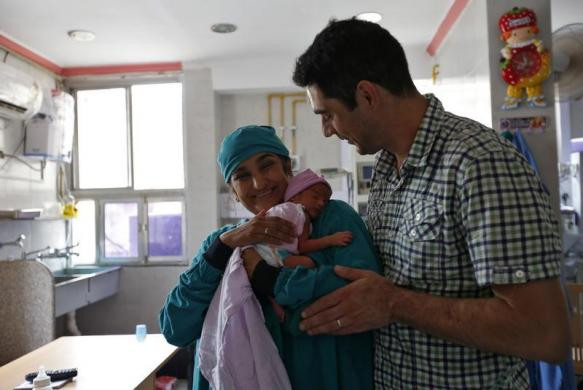 Briton Rekha Patel (42 tuổi) và chồng Daniele Fabbricatore đến từ Anh đang ôm con gái mới một tuần tuổi tại một trung tâm y tế ở Anand.