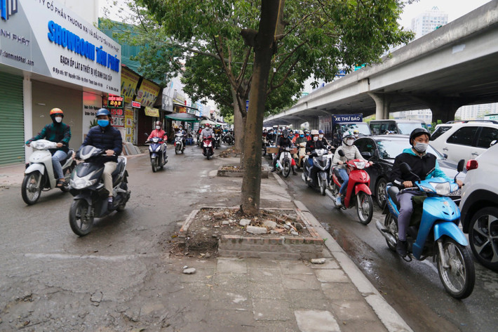 Người đi xe máy lao lên vỉa hè để thoát khỏi cảnh xếp hàng phía sau trên tuyến đường này.
