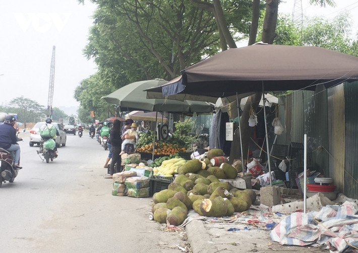 Trên tuyến đường này, “chợ” hoa quả họp suốt ngày. Người dân bày lỉnh kỉnh đồ đạc lên vỉa hè, hoa quả chất thành từng đống.