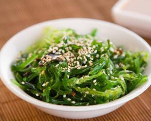 Salad rong biển. Nguyên liệu: Rong biển: 70g; Dưa chuột: 2 quả; Rau xà lách: 100g; Vừng trắng; Gia vị: Đường, muối, tiêu. Dưa chuột rửa sạch, bỏ ruột xắt lát, trộn một chút giấm và đường. Rong biển ngâm rửa sạch sau đó tước thành sợi nhỏ.Vừng rang đến khi vàng thì nhắc xuống. Trộn dưa chuột, rong biển với giấm, đường, muối sao cho vừa. Để ngấm trong 5-10 phút, xếp xà lách vào đĩa cho salad rong biển vào rồi rắc vùng lên trên.