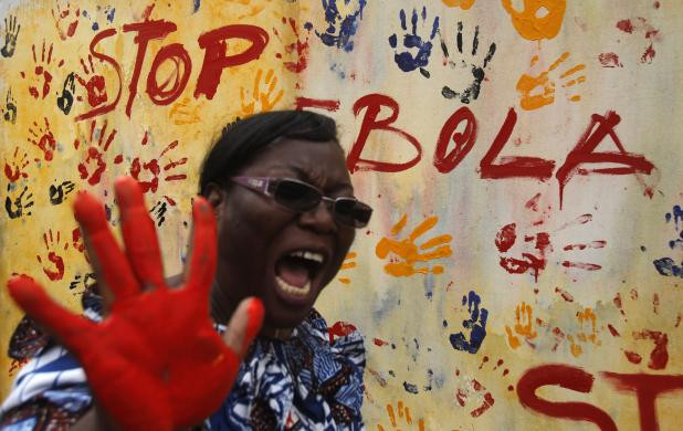 Một giáo viên thể hiện tinh thần quật cường sau khi đánh dấu tay lên bức tường chống Ebola.