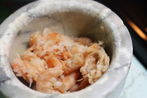 Cho vào cối giã, nếu là tôm khô giả làm từ nhựa hay cao su, thì hình dạng tôm sẽ không thay đổi và thậm chí còn nẩy lên bắn ra ngoài. Nếu là tôm thật thì thân tôm sẽ bị bẹp ra, thịt bung ra từng mảnh.