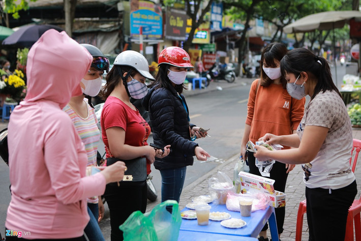 Cảnh mua bán vẫn diễn ra như thường lệ. Chị Thanh Hồng (áo đỏ) cũng tự làm bánh ở nhà để cúng ông bà tổ tiên, chỉ ra chợ mua thêm vài đĩa bánh đem tới cửa hàng của chị. Việc tự làm bánh trong mùa dịch được chị ưu tiên hơn cả vì sạch sẽ, an toàn trong mùa dịch.