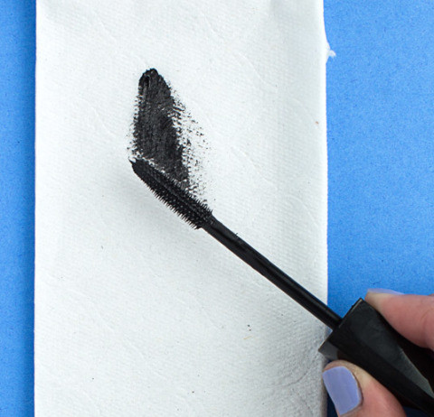 Lau sạch mascara vào khăn giấy trước và sau khi dùng xong để ngăn chặn tình trạng vón cục khi chuốt.