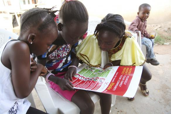 Những đứa trẻ chăm chú đọc tin tức về dịch Ebola được phân phối bởi UNICEF tại Voinjama, Lofa County, Liberia.