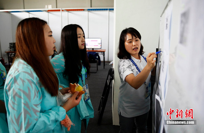Để có được vị trí tình nguyện viên này, Zhou cũng phải trải qua những khóa huấn luyện rất khắt khe, đòi hỏi thể chất cũng như ngoại hình khá.
