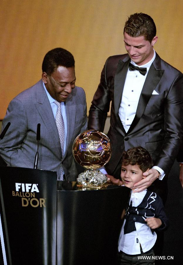 Cristiano Ronaldo với con trai mình. Ánh mắt cậu bé đang khát khao giải thưởng của bố.