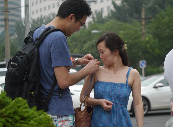 Buộc lại dây váy đã tuột cho bạn gái rất tự nhiên.