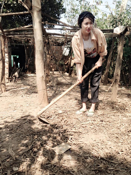 Trong ảnh là Nhã Phương đang vun mùn vào gốc gây, cái nắng nóng làm cô nàng nhăn mặt nhưng vẫn tiếp tục công việc của mình.