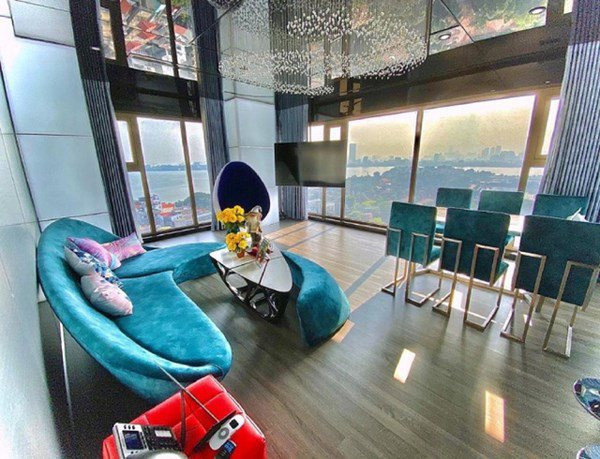 Không gian sống của uyên ương được thiết kế theo phong cách modern & futuristic (hiện đại, tương lai). Ở phòng khách, Claret chọn lựa bộ sofa màu xanh cổ vịt, đèn trần hình giọt nước.