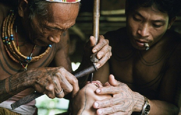 Người thợ dùng một thanh gỗ để làm điểm tựa, rồi trực tiếp mài răng bằng dao hoặc đục. Chỉ cần sơ sảy một chút, cô gái sẽ bị thương.
