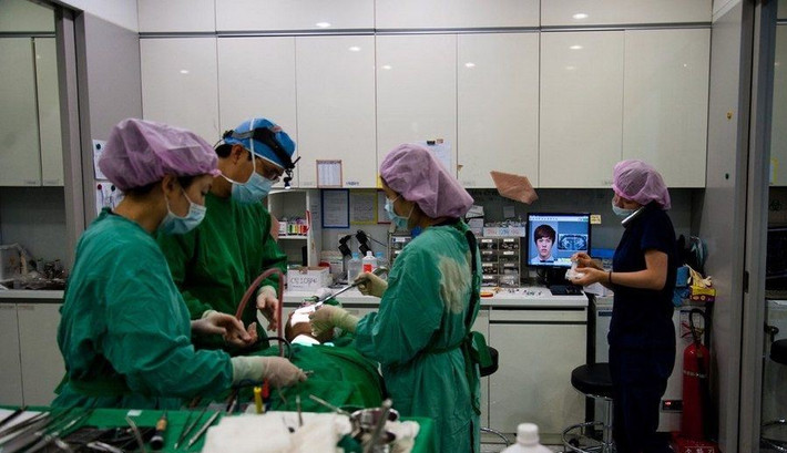 Các bác sĩ đang tiến hành thực hiện các thủ thuật phẫu thuật thẩm mỹ trong phòng phẫu thuật.