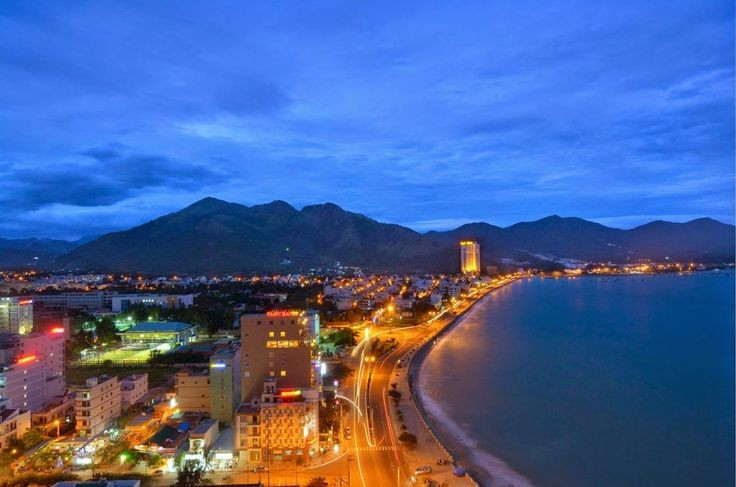ឆ្នេរ Nha Trang (Khanh Hoa) ។ ខ្សាច់ពណ៌ស និងពន្លឺព្រះច័ន្ទពណ៌មាសដែលឆ្លុះបញ្ចាំងលើរលក បង្កើតបរិយាកាសរ៉ូមែនទិកដែលមិនអាចពិពណ៌នាបាន។ រូបថត៖ Pinterest ។ Biển Nha Trang (Khánh Hòa). Bãi cát trắng cùng ánh trăng vàng rực phản chiếu trên sóng biển tạo nên không gian lãng mạn khó tả. Ảnh: Pinterest.