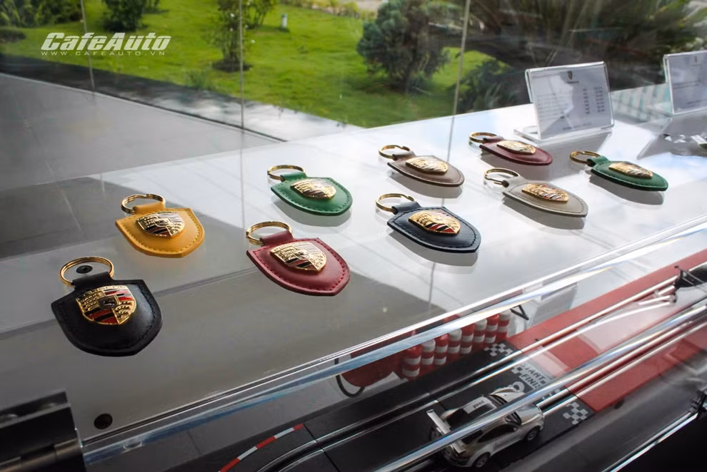 Những chiếc móc khóa có logo Porsche với nhiều màu sắc.