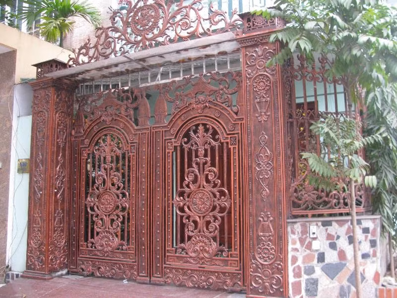 Một chiếc cổng màu đỏ đồng với hoa văn cầu kỳ trong khu Văn Quán.