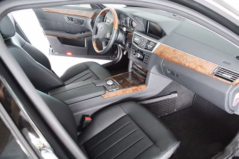 Về nội thất, E-Class sử dụng các chất liệu da và nhựa tối màu cao cấp kết hợp cùng các chi tiết ốp gỗ sang trọng. Hệ thống bảng tablo mang những nét đặc trưng của Mercedes với cụm bảng đồng hồ lái và màn hình trung tâm nằm trong một mái vòm.