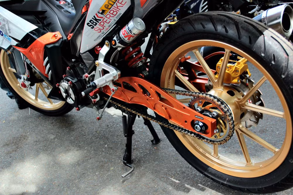 Gắp Racing Boy và bảo vệ lốc nồi Racing Boy. ​Dàn tem đấu ấn tượng cùng các hốc gió chế mũ tạo cảm giác 1 con xe đầy "chất" đường phố, rất nổi bật giữa đám đông, và với nội công trái 62mm, pô Arrow cho hiệu quả giải tán đám đông tích tắc. Ảnh: ABMiracle.