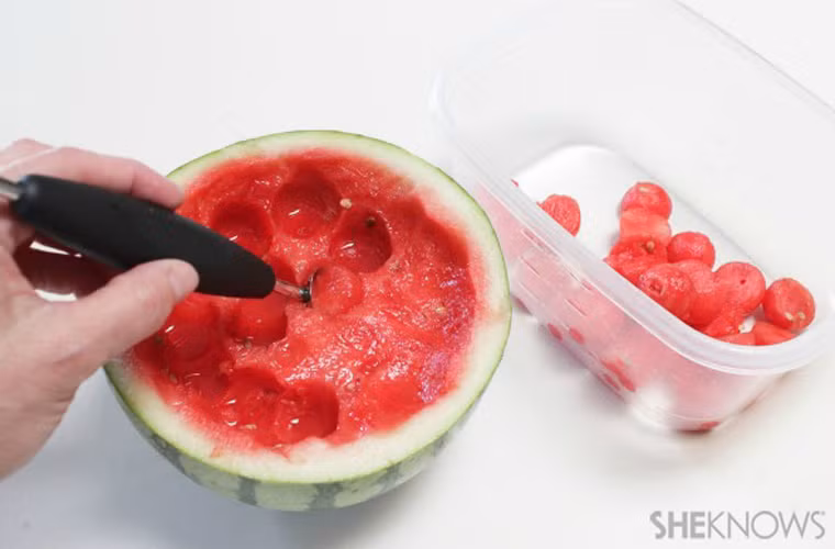 Sử dụng thìa tròn nhỏ để múc ruột dưa hấu ra chiếc bát nhỏ.