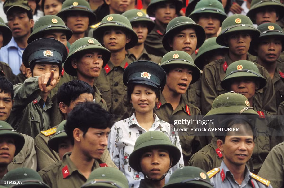 Một bóng hồng nổi bật giữa sắc phục xanh của các quân nhân.