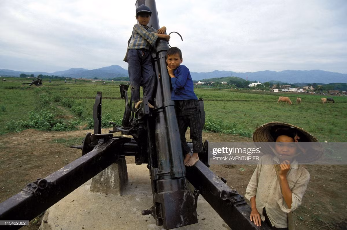 Trẻ em leo trèo trên một khẩu pháo ở cánh đồng Mường Thanh, nơi từng là chiến trường khốc liệt 40 năm trước.
