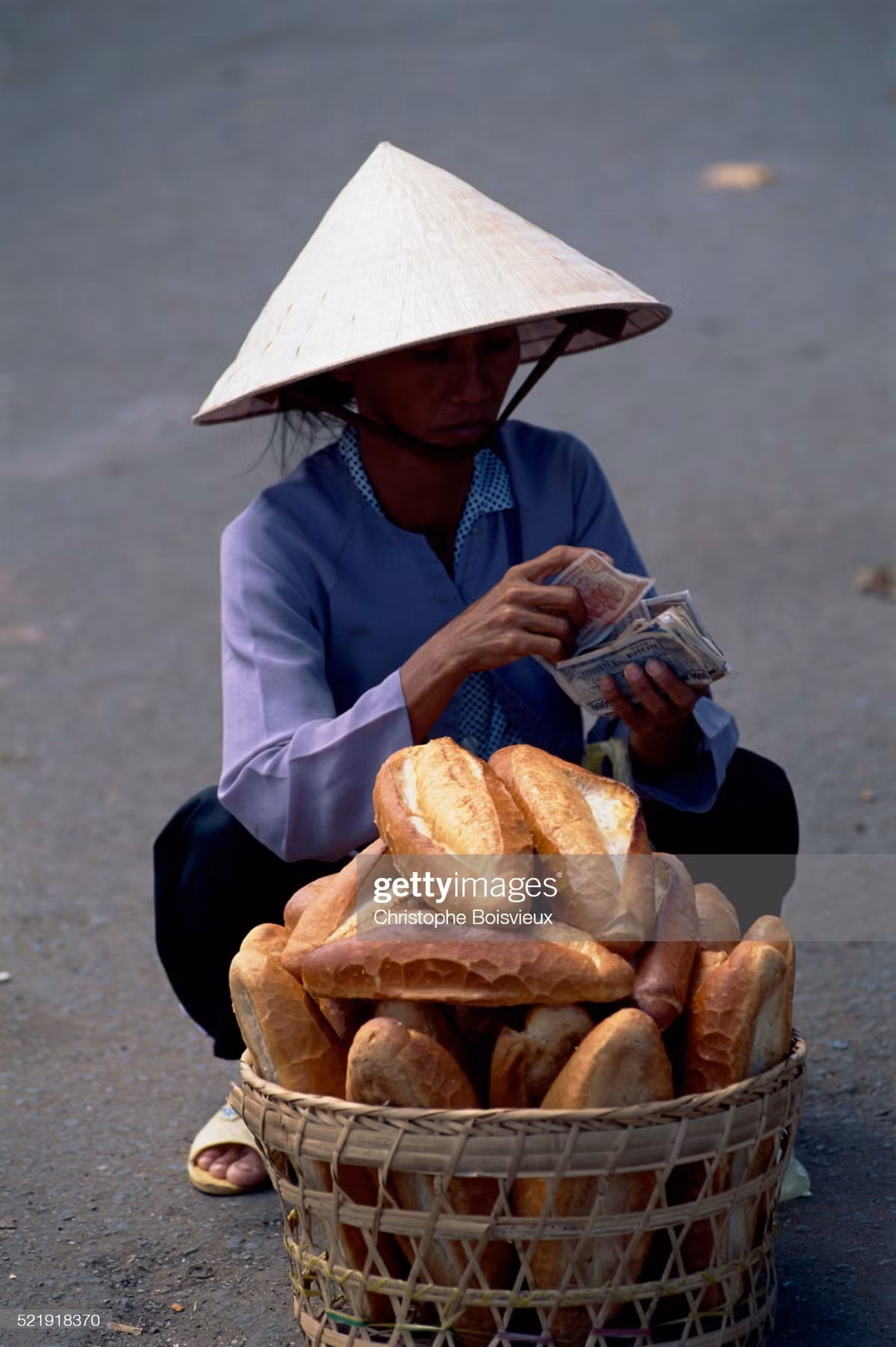 Người bán bánh mì kiểm đếm tiền bán hàng thu được.