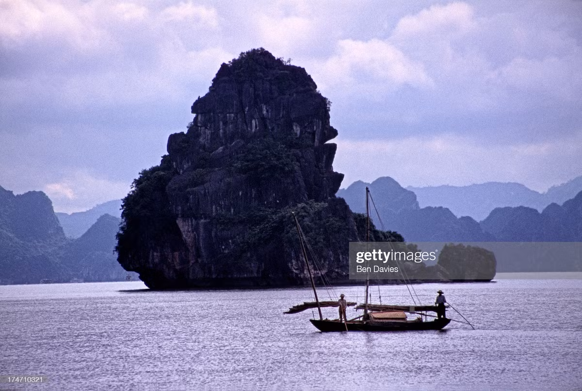 Con thuyền nhỏ bên đảo đá có hình thù kỳ lạ ở vịnh Hạ Long.