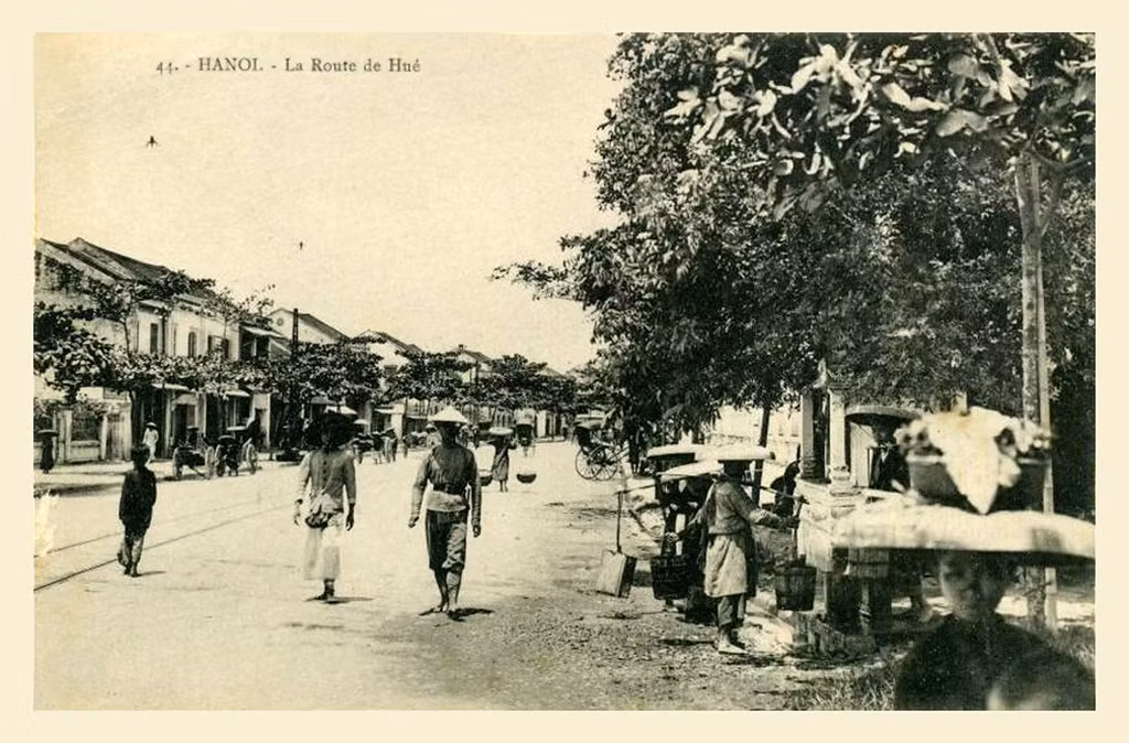 Đời thường trên phố Huế xưa. Những người phụ nữ đang lấy nước ở vòi nước công cộng trên vỉa hè (bên phải).