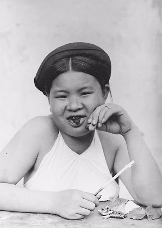 Cô gái mũm mĩm bỏm bẻm nhai trầu.