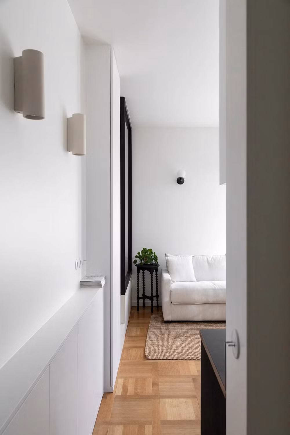 Nếu không để ý kỹ, bạn sẽ khó mà phát hiện ra những chiếc tủ âm tường được đặt trong căn hộ này. Những cánh tủ màu trắng đồng điệu với sơn tường giúp chúng ẩn mình thành công khỏi mắt người nhìn. Những chiếc tủ âm tường giữ vai trò là kho lưu trữ, giúp Linn sắp xếp căn hộ của bản thân luôn thật gọn gàng, ngăn nắp.