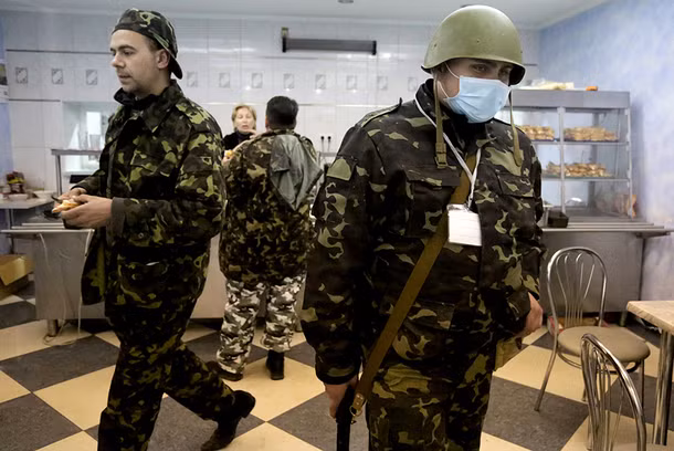 Một số những người đánh chiếm trụ sở Cơ quan an ninh Ukraine (SBU) ở Lugansk đang tranh thủ uống cà phê. Tuy nhiên, họ vẫn luôn lăm lăm súng trên tay.