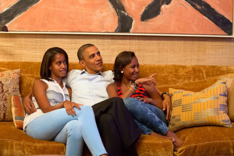 Tổng thống Barack Obama và 2 cô con gái cưng, Malia (trái) và Sasha cùng ngồi xem truyền hình ngày 4/9/2012.