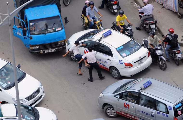 Đầu tiên tài xế xe tải đạp gãy kính chiếu hậu bên phải của xe taxi, sau đó lao vào đánh tài xế taxi.
